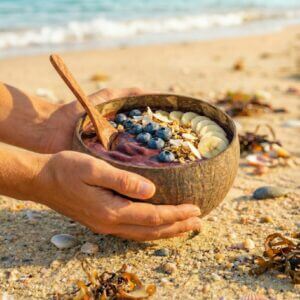 Coconut Bowl Taijitu mit Acai und Kokosnusslöffel am Strand